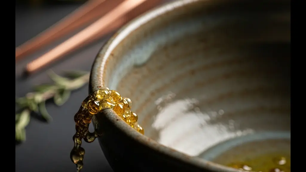 Nahaufnahme einer handgefertigten Keramikschale mit kunstvollen Texturen auf einer dunklen Schieferoberflaeche, daneben feine Kuechenutensilien aus Kupfer