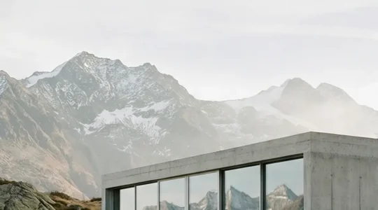 Moderne Sichtbeton-Architektur in den Schweizer Alpen, die sich harmonisch in die Berglandschaft einfügt.